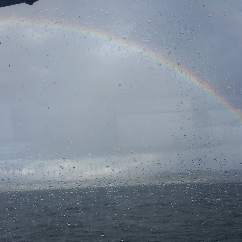 A rainbow arching over the water after rain